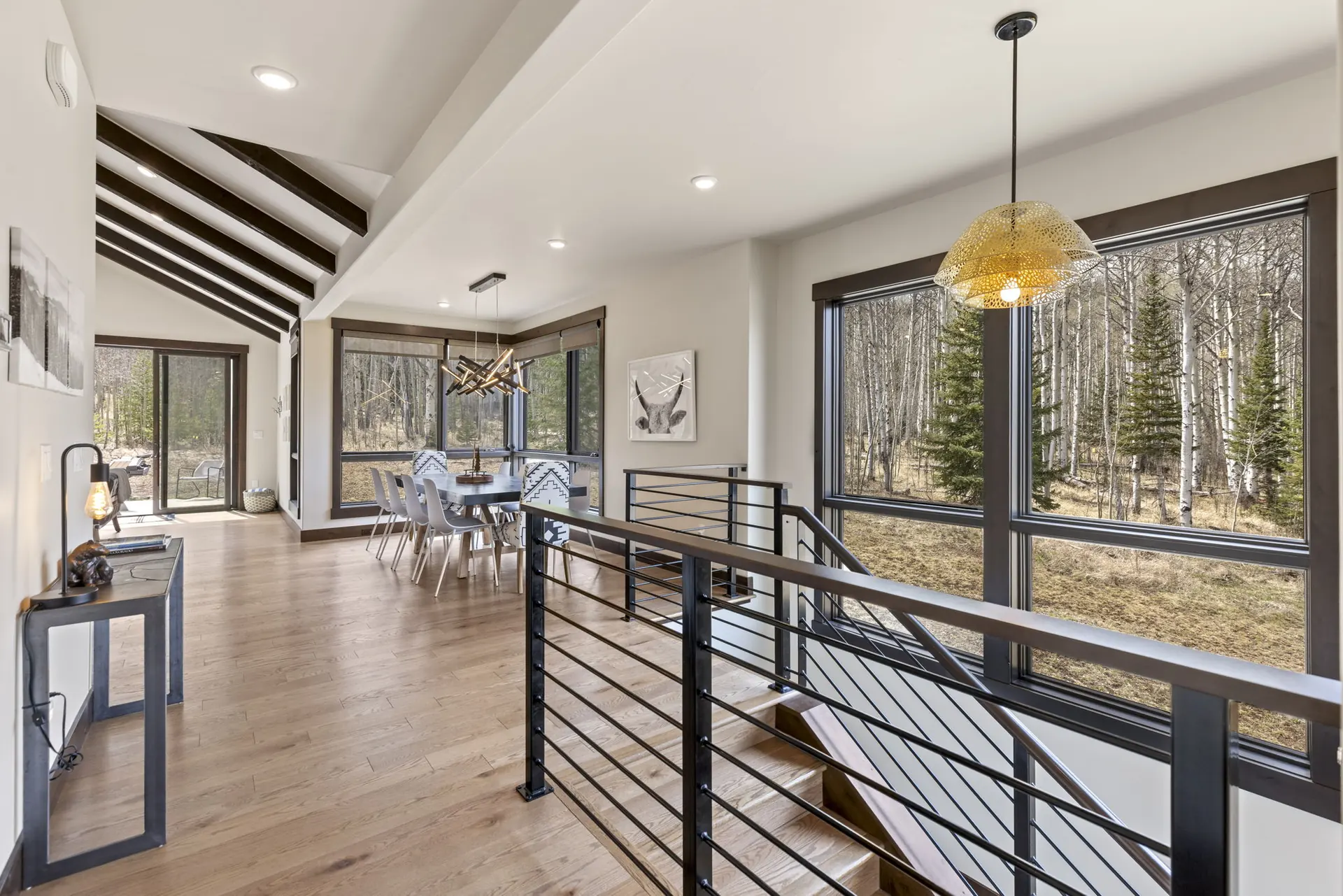 Vendette Peak, details: Upper-level landing with a cable railing, stair opening, dining table, and windows facing the forest, luxury vacation rental in Silverthorne, Colorado